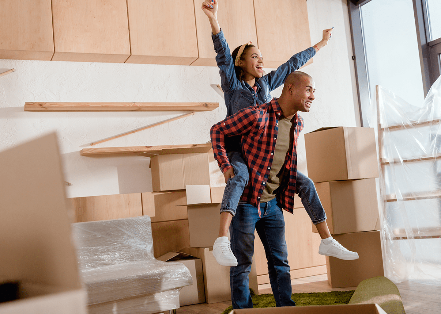Man giving woman piggyback while woman raises arms