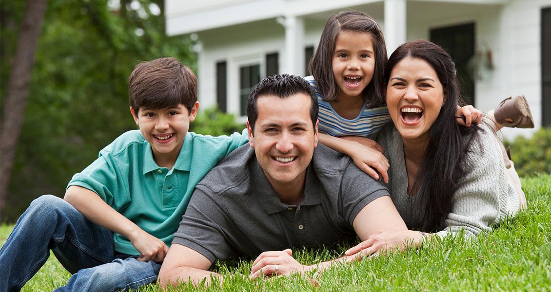 Family of four smiling for camera