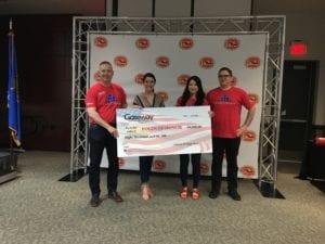 Individuals holding large donation check.